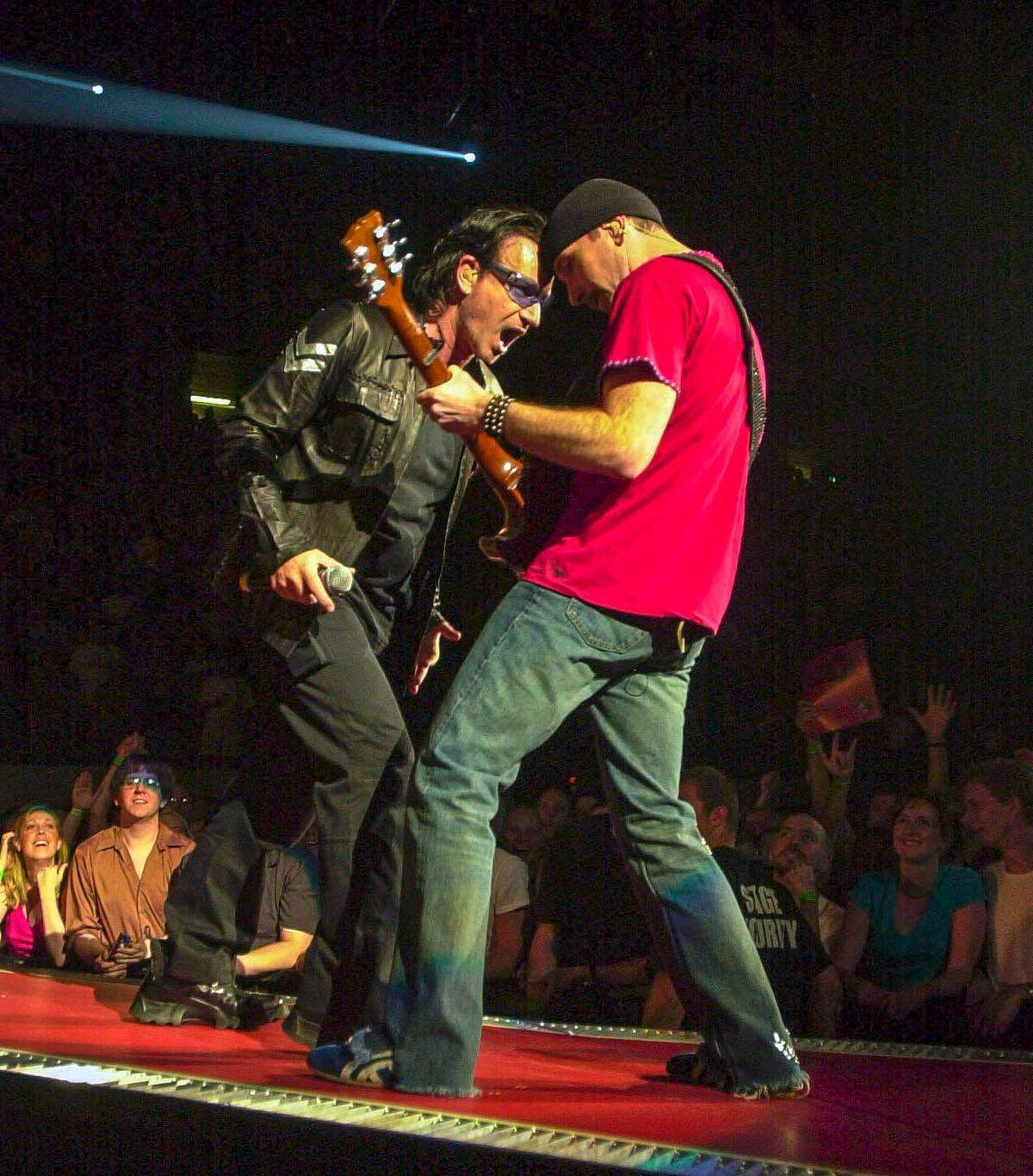 L-R, Bono, lead singer to the band U2, interacted with lead guitarist Edge at their concert at Rupp Arena in Lexington Ky., May, 4, 2001.