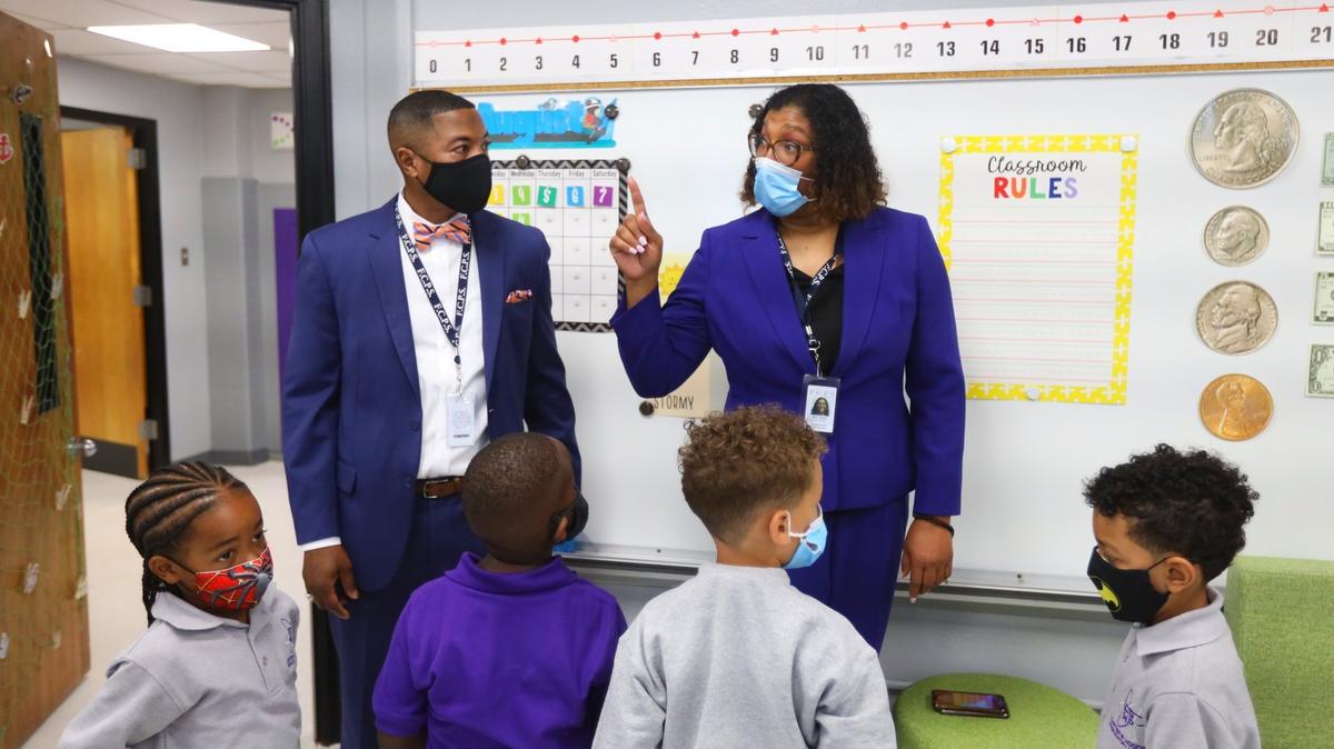 Superintendent Demetrus Liggins, left, listens as Carter G Woodson Academy program director Jocelyn Mills, right, directs 1st grade students’ attentions for their first day of class, August 11, 2021.