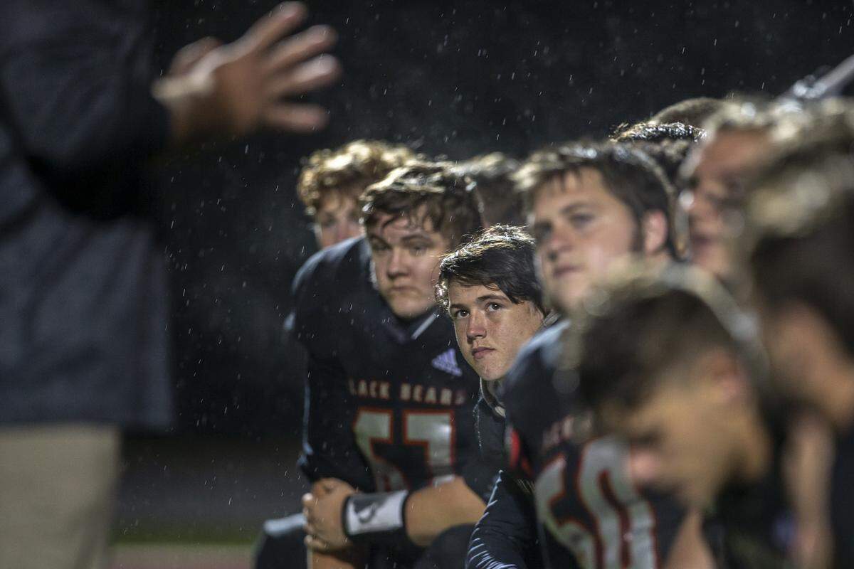 Harlan County players listen as head coach Eddie Creech speaks to the team following the game.