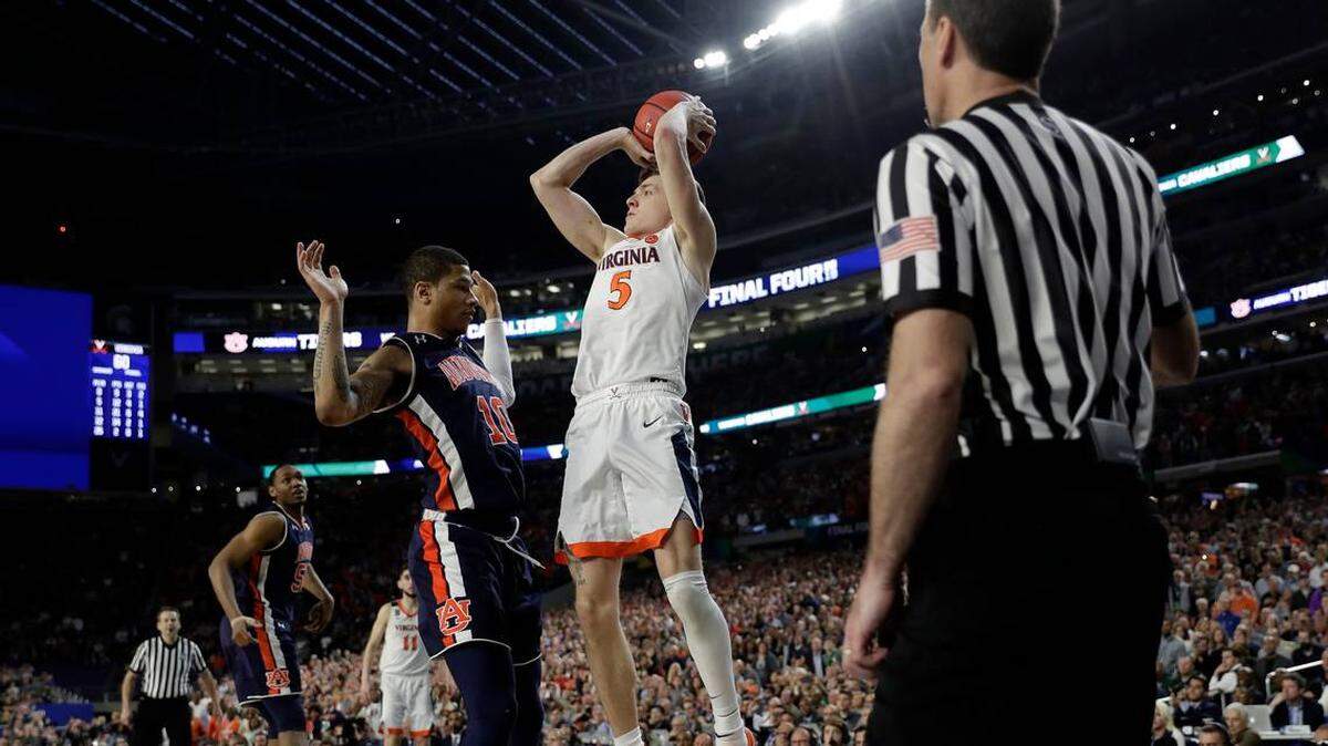 Virginia’s Kyle Guy (5) takes a shot as Auburn’s Samir Doughty (10) was called foul during the second half in the semifinals of the Final Four NCAA college basketball tournament, Saturday, April 6, 2019, in Minneapolis.