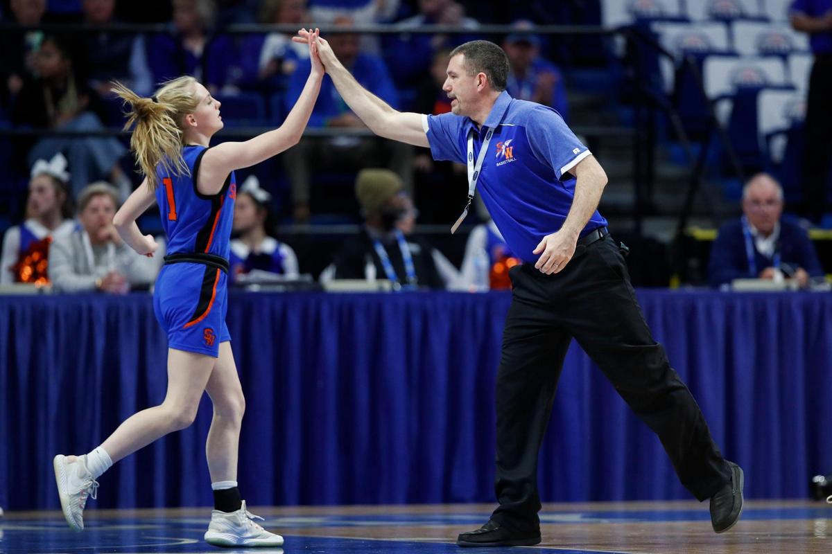 Southwestern head coach Junior Molden high-fives Jessalyn Flynn (1) during the Warriors’ first-round win Wednesday night.