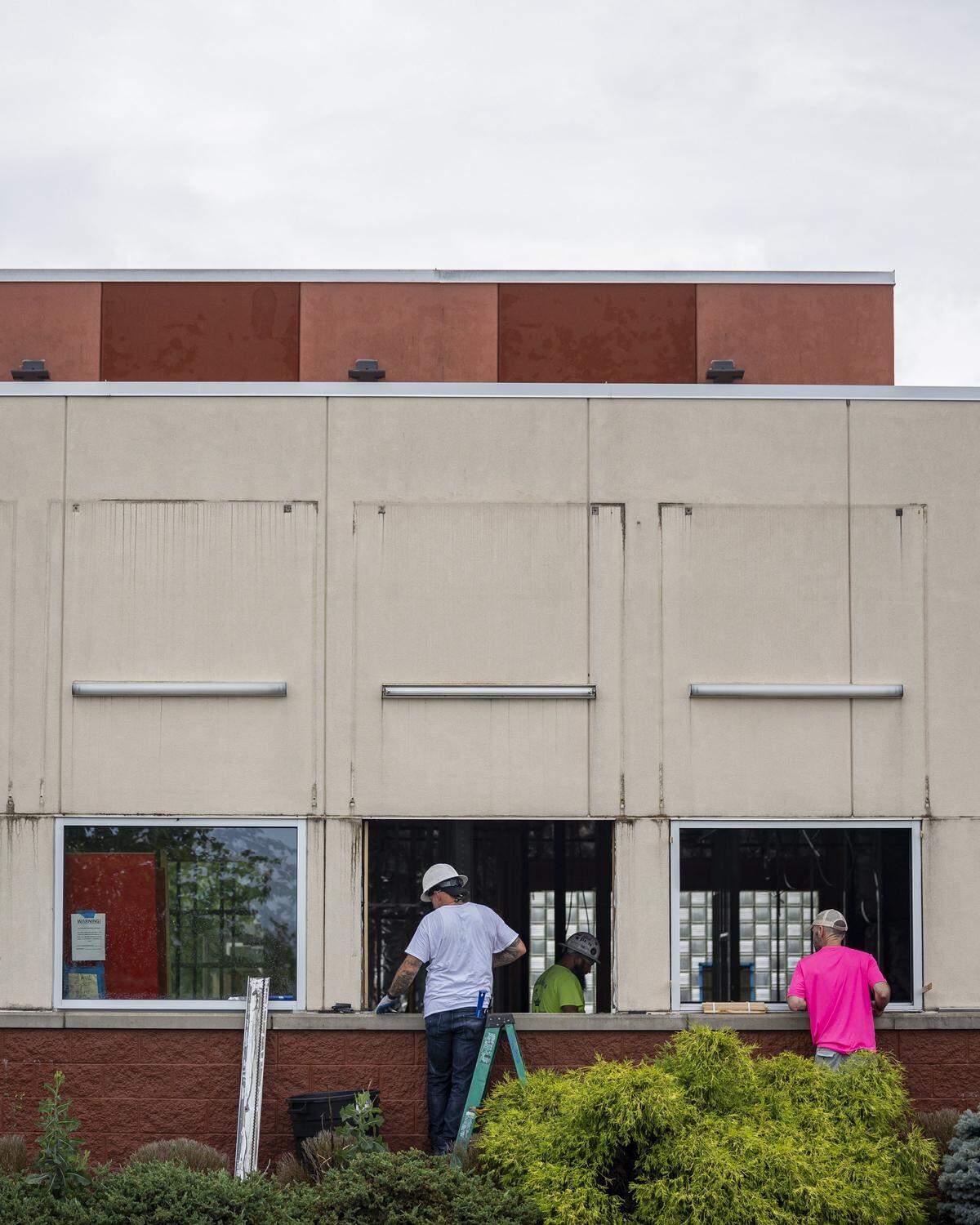Levi Jolly, left, Jeremy Mallet, center, and another worker from Aladdin’s Glass, remove the frame from a window during construction of a new dispensary on Wednesday, July 9, 2025, at the old Frisch's Big Boy in Hamburg in Lexington, Ky.