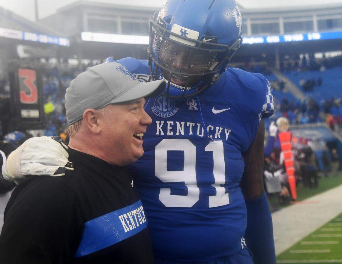 UK senior Calvin Taylor celebrated with Wildcats Coach Mark Stoops in the closing seconds of UK’s 45-13 victory over archrival Louisville in the 2019 regular-season finale.
