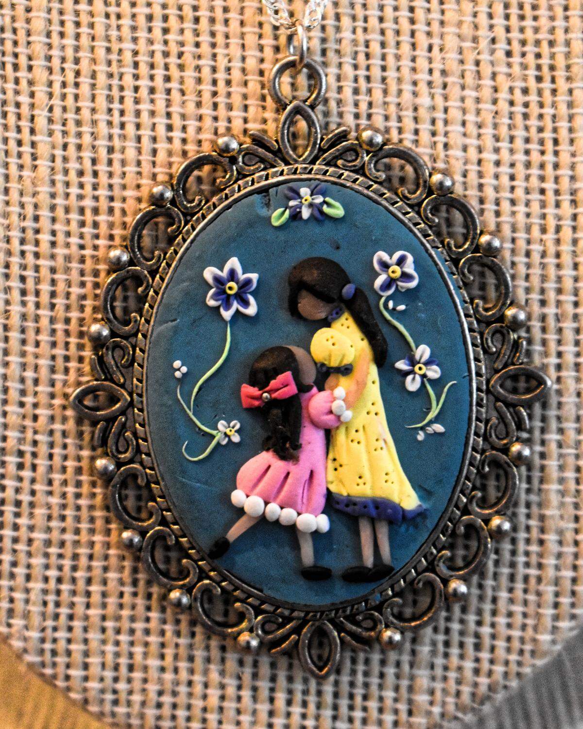 A cameo-style pendant made to celebrate Mother’s Day features a mother and daughter. Artist Almeta Dellagnolo says she made “many different ethnicities and colors. I want all people to feel like they’re represented in the work.”