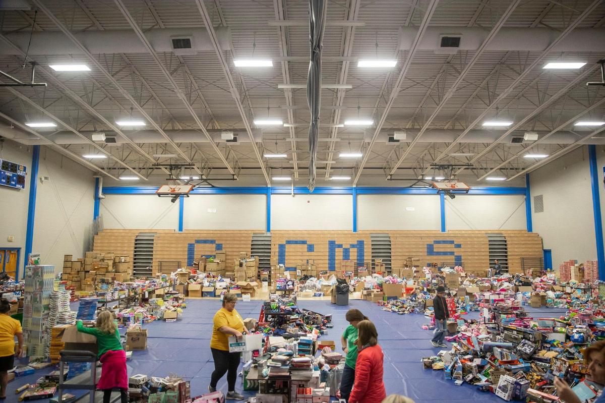 Volunteers help sort toys at Graves County Middle School in Mayfield, Ky., on Monday, Dec. 20, 2021, during the distribution of Christmas gifts donated for students affected by the deadly tornado that ripped through the county earlier in December.