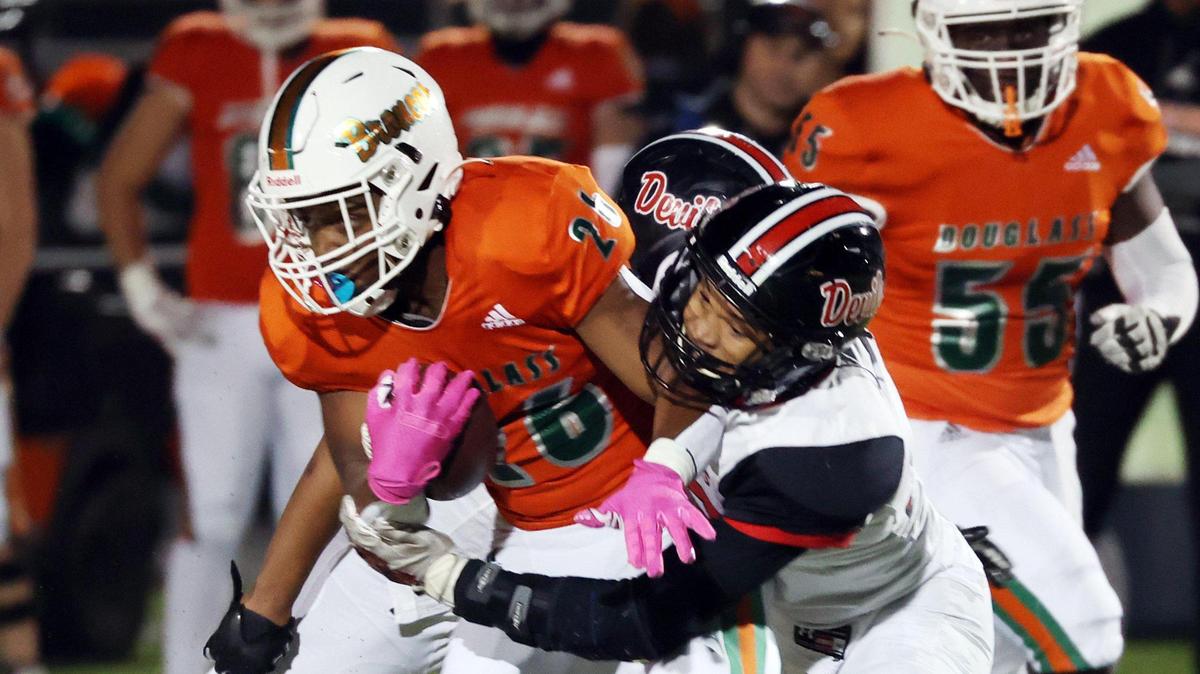Frederick Douglass’ Logan Busson, left, is wrapped up by Owensboro’s Kanye Johnson during the state semifinals in Lexington on Friday night. The Broncos won 14-2.