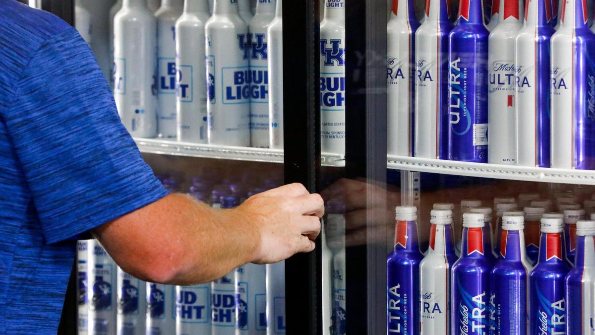 A University of Kentucky football fan selects a beer from a cooler before Saturday’s home opener. UK is making alcohol available to all fans at Kroger Field for the first time this season.