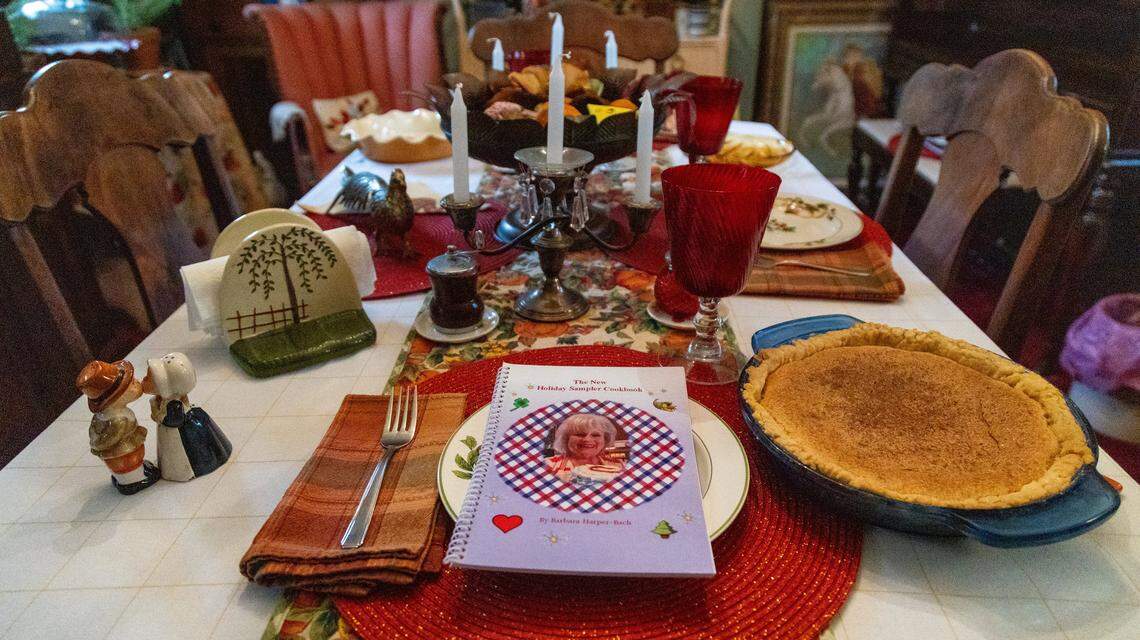 Barbara Harper Bach's kitchen table decorated for Thanksgiving with her final cook book, The New Holiday Sampler Cookbook, next to a chess pie she baked.
