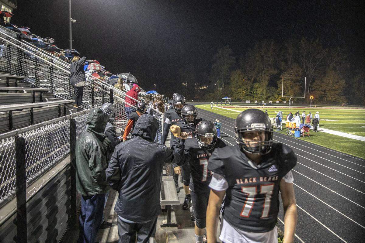 The Black Bears walk past family, friends and supporters before taking the field.