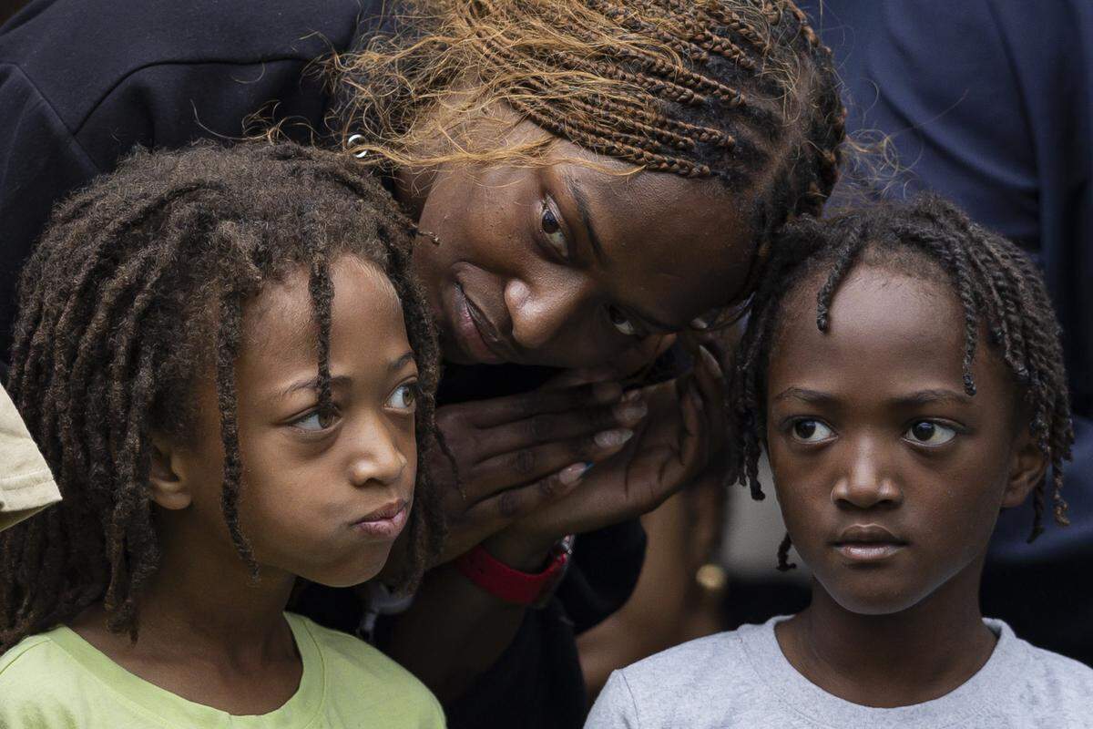 A mother shares amount with her sons during the ‘Towards Freedom’ monument unveiling on Thursday, June 19, 2025, at the corner of North Limestone and Fourth Street in Lexington, Ky.