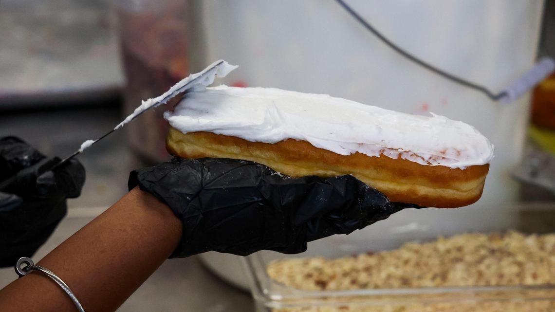 A long john gets a coating of vanilla icing at Jeff’s Donuts, Thursday, Jan. 23, 2025, in Lexington, Ky. Jeff’s is known for is large menu of long john varieties that can be filled or unfilled.