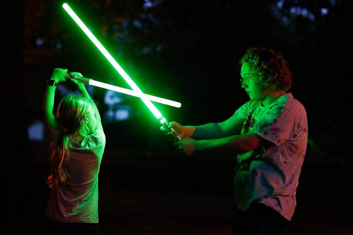 Williams Atkinson instructs Peri Buck, 9, during a practice session with the Lexington Lightsaber League at Woodland Park.