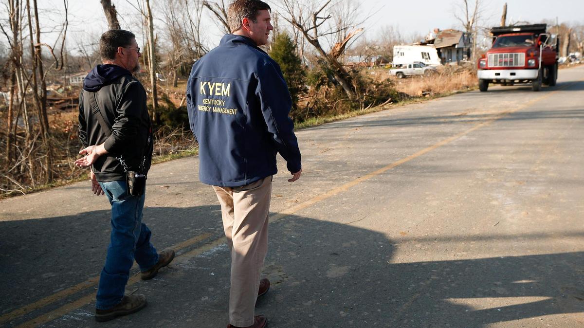 Bremen Mayor Allen Miller, left, leads Kentucky Gov. Andy Beshear through a tornado-ravaged area of Bremen, in Muhlenberg County, Ky., Tuesday, Dec. 14, 2021.