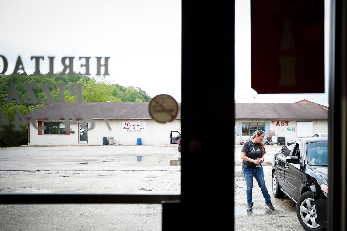 Melissa Chitwood, of Jellico, Tenn., speaks with a customer as they pick up an order at Heritage Pizza in Jellico, Tuesday, May 5, 2020. Chitwood and other family members who work at Heritage have chosen to keep their dining room closed as other restaurants in the area begin to open theirs.