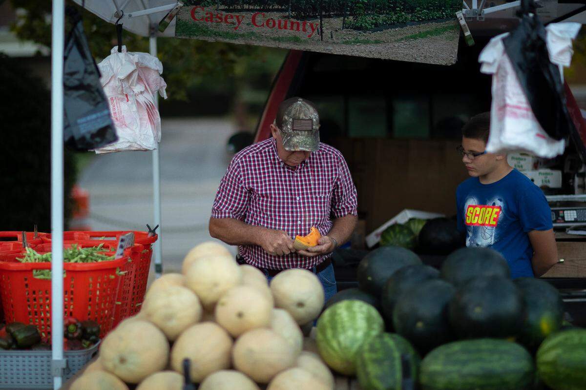 Marion Pittman, left, and Ryan Hayes, of Pittman Produce in Casey County, ready their stand at the Lexington Farmers Market at the corner of Maxwell Street and South Broadway on Thursday, Aug. 26, 2021. The Tuesday and Thursday market will be moving to National Avenue.