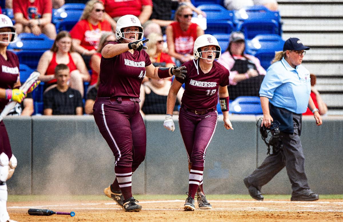 Henderson County’s Mackenzie Burczyk (44) and Addison Duncan (18) cheer on their teammates from home plate during the state softball semifinals against Scott County on Friday.