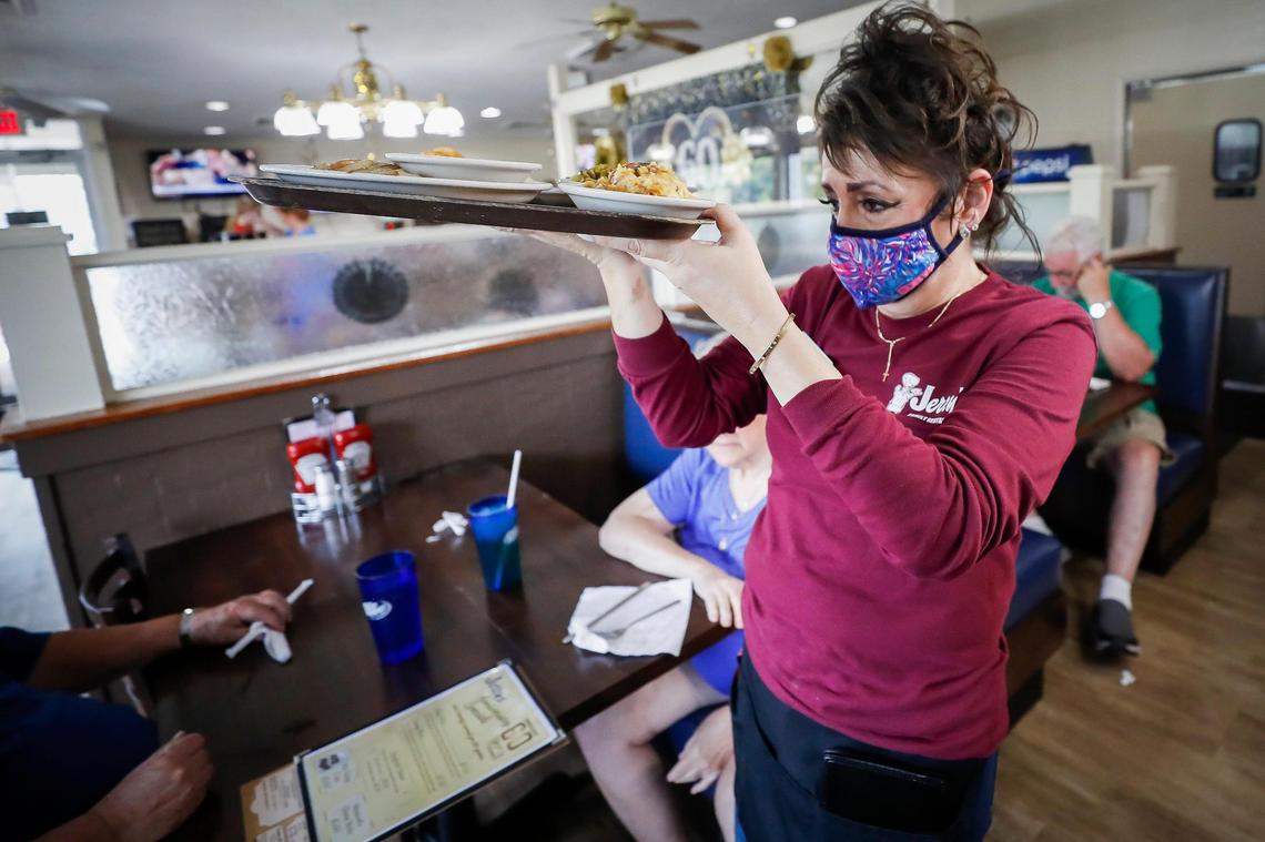 Linda Ashby carries a tray of food through the dining room at Jerry’s Restaurant in Paris Wednesday, July 7. Ashby has worked at Jerry’s for nine years.
