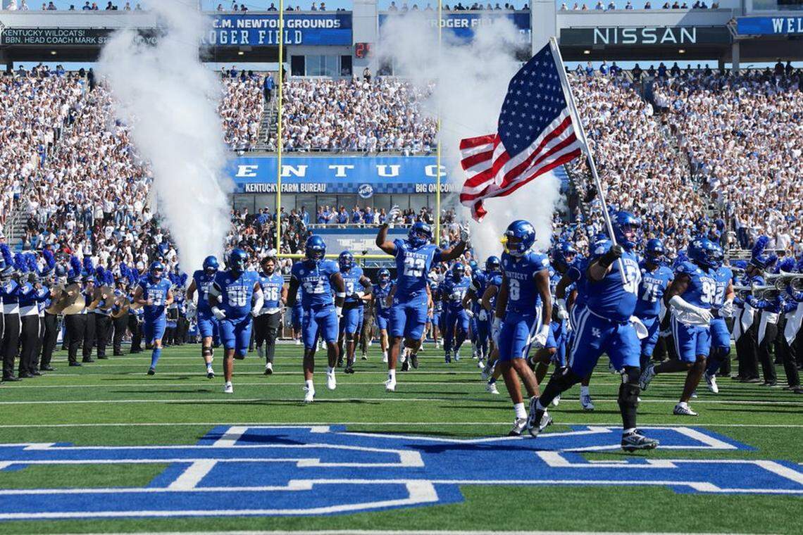 The Kentucky football team runs onto the field ahead of its game against South Carolina on Saturday at Kroger Field.
