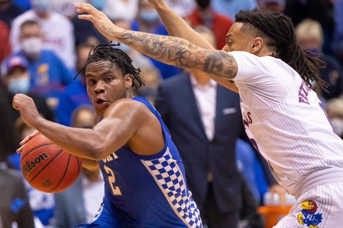 Kentucky Wildcats guard Sahvir Wheeler (2) drives past Kansas Jayhawks guard Bobby Pettiford (0) during a game at Allen Fieldhouse in Lawrence, Kansas, on Saturday, Jan. 29, 2022.