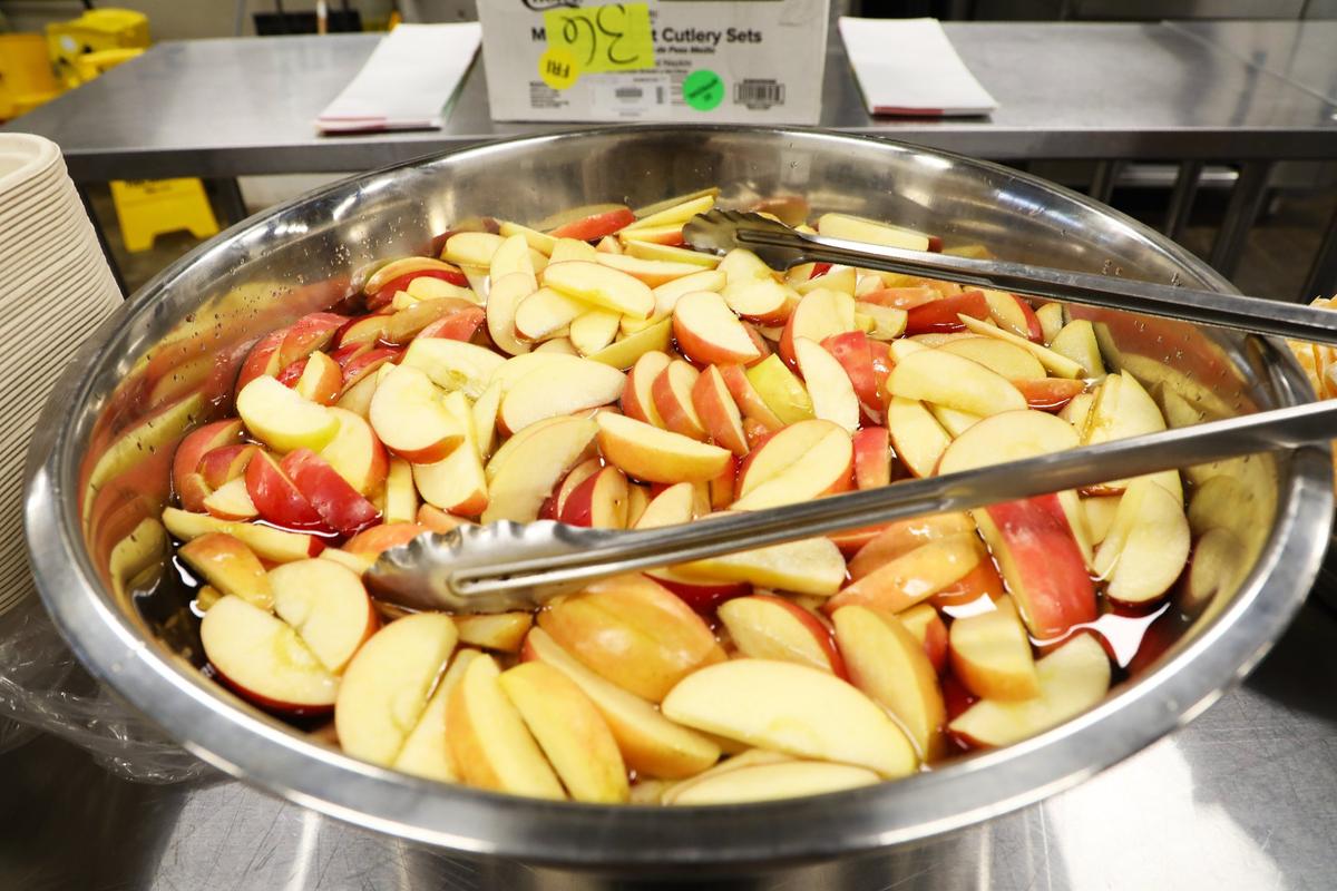 Freshly sliced apples soak in purified water, awaiting portioning for nutritious pre-packed school lunches customized to each student’s needs through “Packed,” a new venture from FoodChain founder Becca Self, on December 3, 2024, in Lexington, Ky.