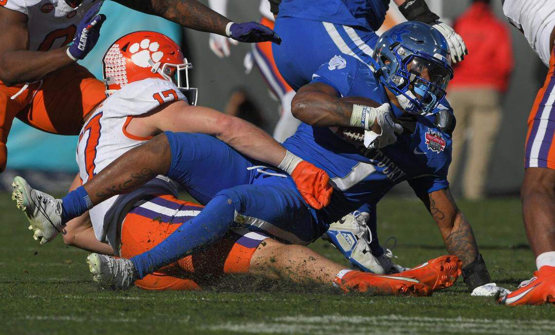 Clemson linebacker Wade Woodaz (17) tackles Kentucky running back Ray Davis (1) during the fourth quarter of the TaxSlayer Gator Bowl.