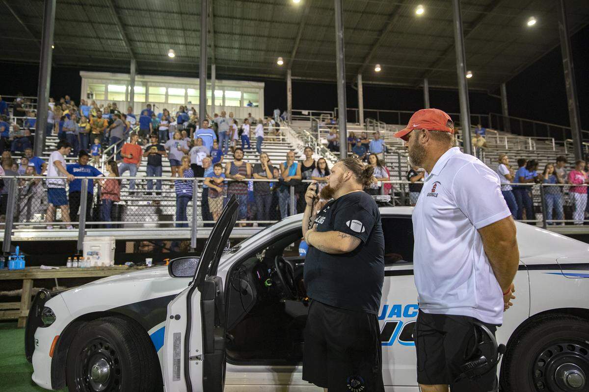 Because the stadium PA system was down, Jarrod “J-Rod” Neace uses the loud speaker on a police cruiser to announce the MVPs of the Honey Bowl.