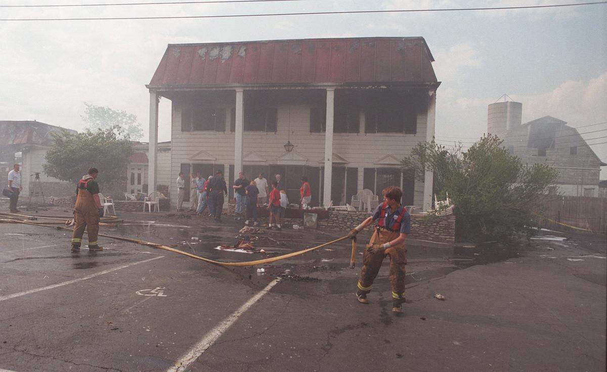 Firefighter Bobby Cravens with the Simpsonville Volunteer Fire Department, rolls up a fire hose after a fire destroyed the Claudia Sanders Dinner House Restaurant west of Shelbyville, Ky., May 11, 1999.