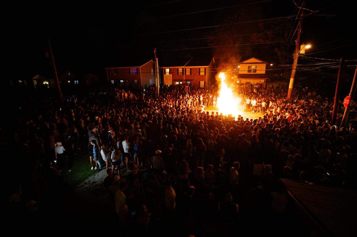 Fans crowded around a fire on State Street Saturday night after the University of Kentucky Wildcats’ football win over the Florida Gators.