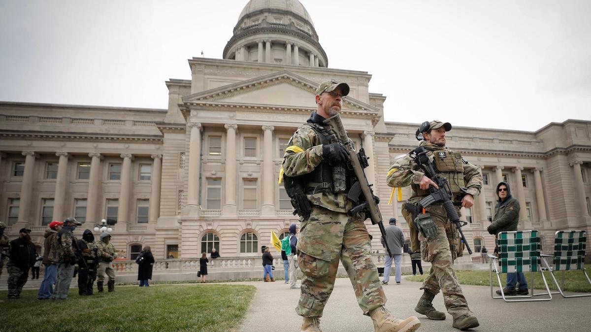 Armed men patrol during a protest at the Kentucky State Capitol in Frankfort, Ky., Saturday, Jan. 9, 2021.