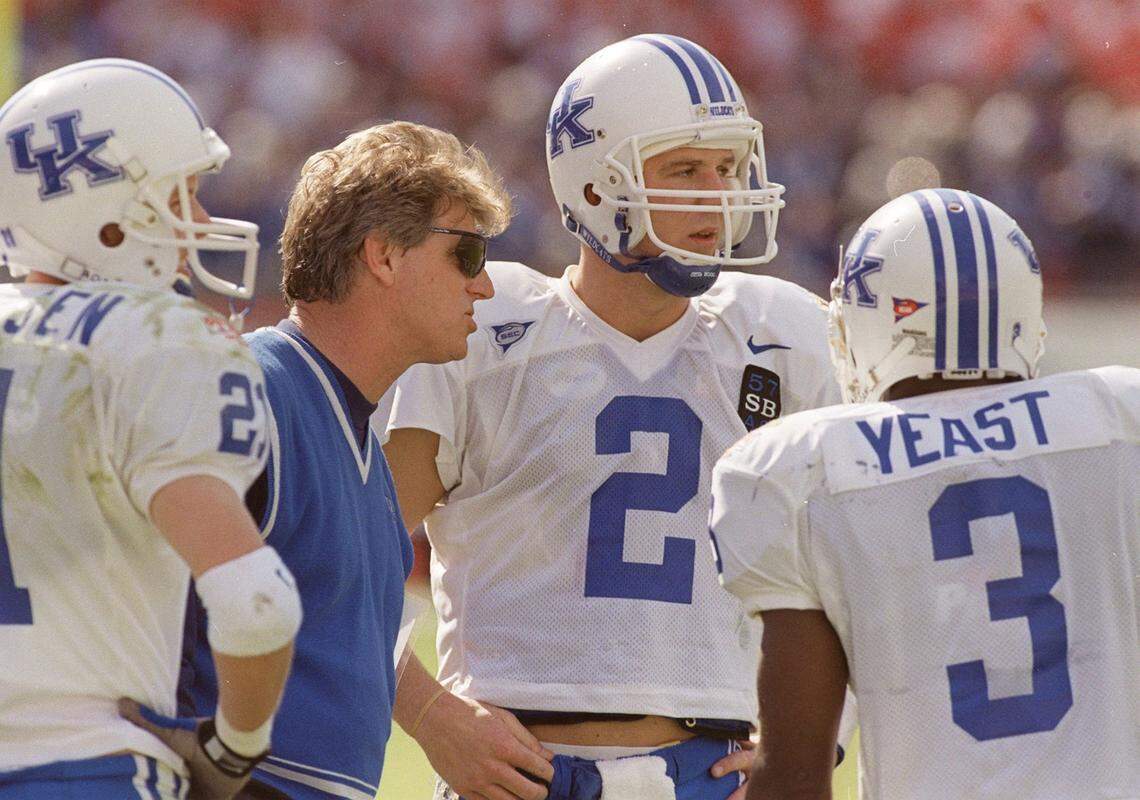 Kentucky head coach Hal Mumme talks with quarterback Tim Couch (2) and wide receivers Lance Mickelsen (21) and Craig Yeast (3) during the Outback Bowl against Penn State in Tampa, Florida, on Jan. 1, 1999. John Clay remembers more about that trip than the football and the sunshine.