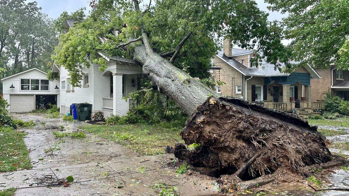 A large tree fell on a home in Arcadia Park Friday, Sept. 27, as the remnants of Hurricane Helene pummeled Kentucky with rain and strong winds.