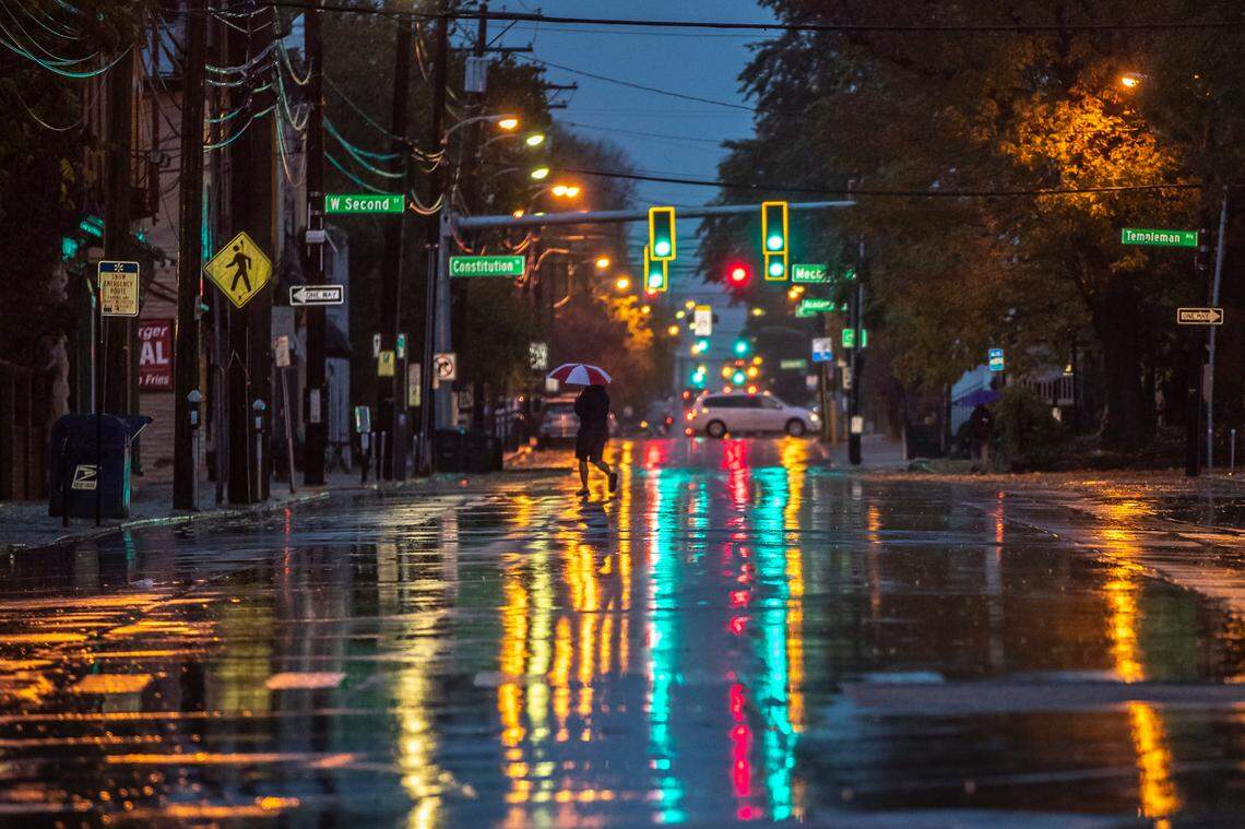 A pedestrian crosses Limestone during a morning drizzle in downtown Lexington, Ky., on Tuesday, Oct. 20, 2020.