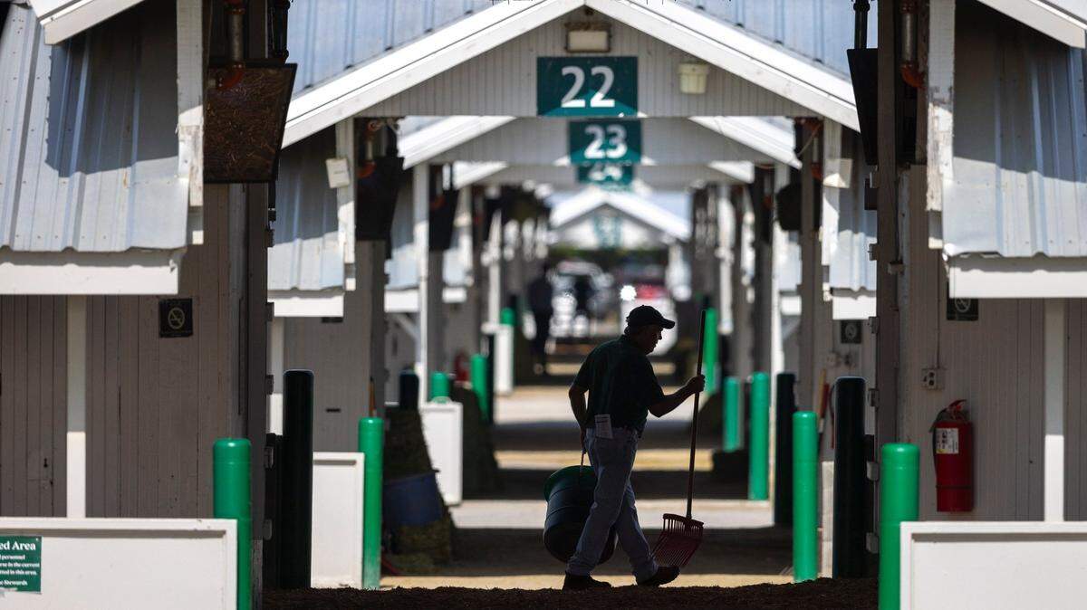 A worker walks through the barn area during opening day of the Keeneland Fall Meet in Lexington, Ky., Oct. 6, 2023. The racetrack was mentioned as a boon to Lexington, which was selected as a top travel destination in 2025 by Bloomberg.