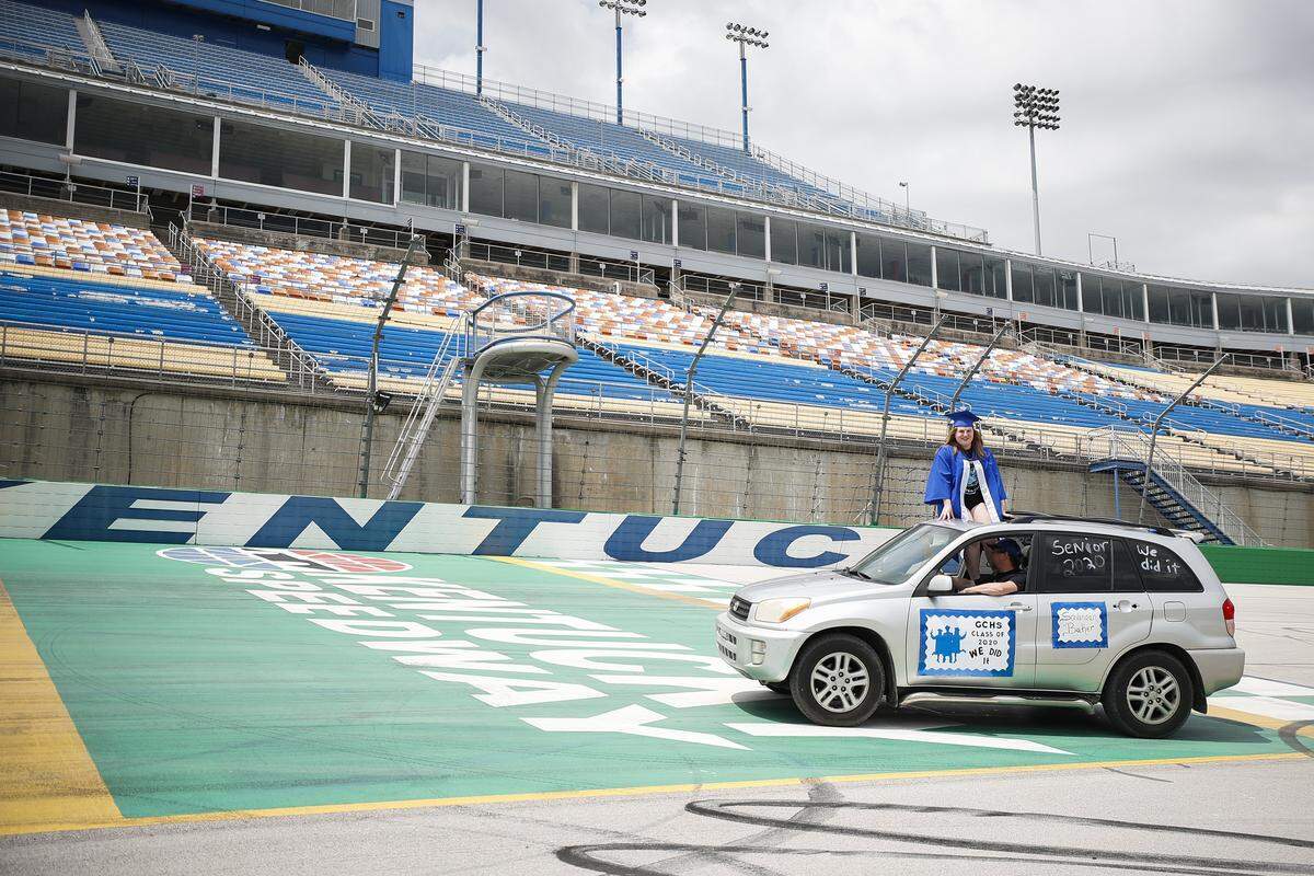 Graduating Gallatin County High School senior Savannah Baker stands out of the sunroof of her parent’s car to pose for a picture after taking a “victory lap” around the 1.5 mile track at Kentucky Speedway in Sparta, Saturday, May 23, 2020. Saturday’s lap around the track was part of Gallatin County’s graduation ceremony.