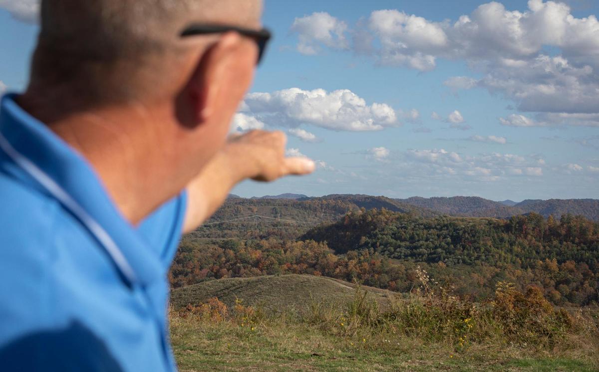 Airport manager and fixed base operator at the Big Sandy Regional Airport, Gary Cox, points out landmarks from a viewpoint along trails on former mining land in Martin and Pike Counties, near Debord, Ky., Thursday, October 22, 2020. Cox has started to offer side-by-side adventure tour rides from the airport that go through the reclaimed mine land around Debord in hopes of showing off how beautiful the land is and growing the tourism industry in the area.