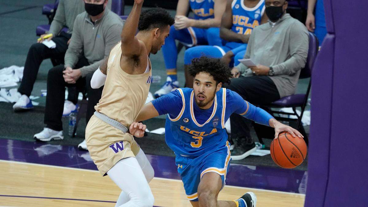 UCLA’s Johnny Juzang (3) slipped past Washington’s Jamal Bey during the second half Saturday. Juzang is averaging 14.2 points, 4.1 rebounds and 1.7 assists this season.