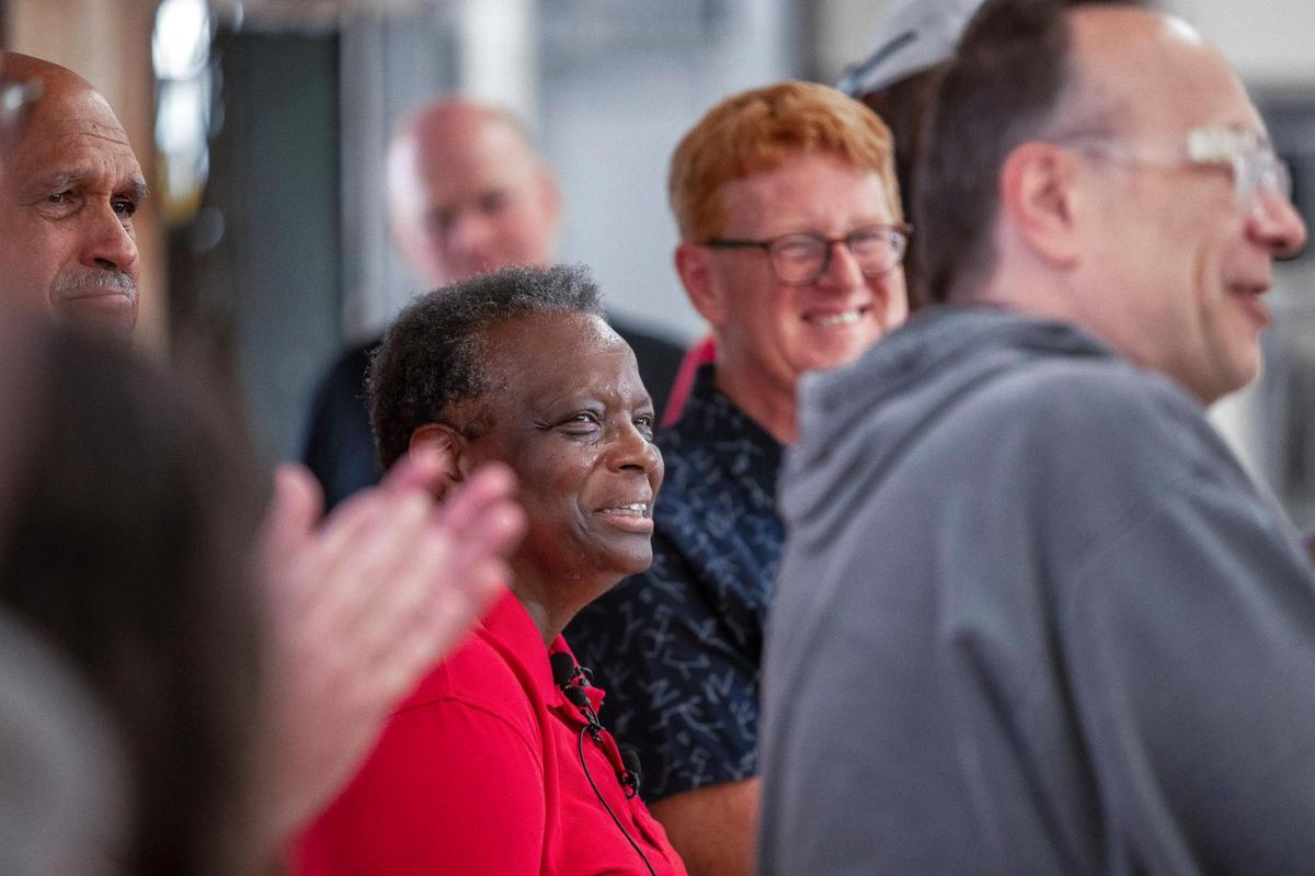 Arthur, from left, and Gwen Christion, owners of the Isom IGA, listen as Father Jim Sichko — the Papal Missionary of Mercy from Lexington — explains that he’s giving the family $75,000 to help reopen the store on Wednesday, Aug. 31, 2022. The grocery store was devastated by flood waters in July.