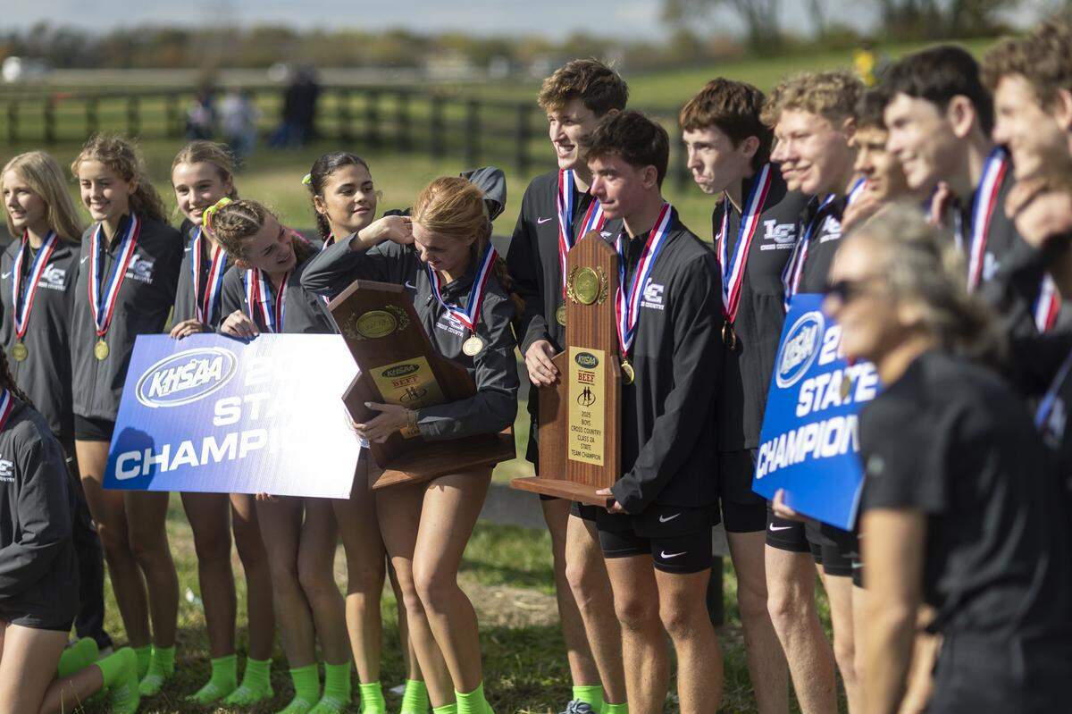 The Lexington Catholic boys' and girls cross country teams pose for photos with their championship trophies at the 2025 KHSAA Class 2A State Cross Country Meet at the Kentucky Horse Park in Lexington, Ky., on Saturday, Nov. 1, 2025.