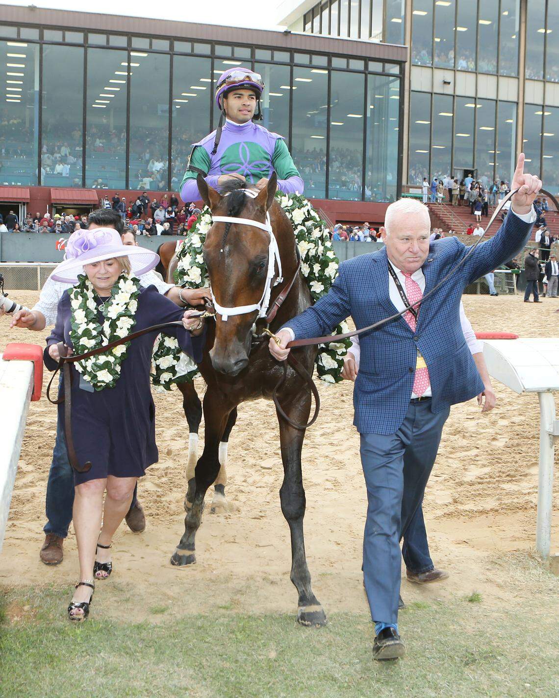 Owners Robert and Lawana Low led Magnum Moon with jockey Luis Saez up to the winner's circle for the Arkansas Derby at Oaklawn Park on April 14.