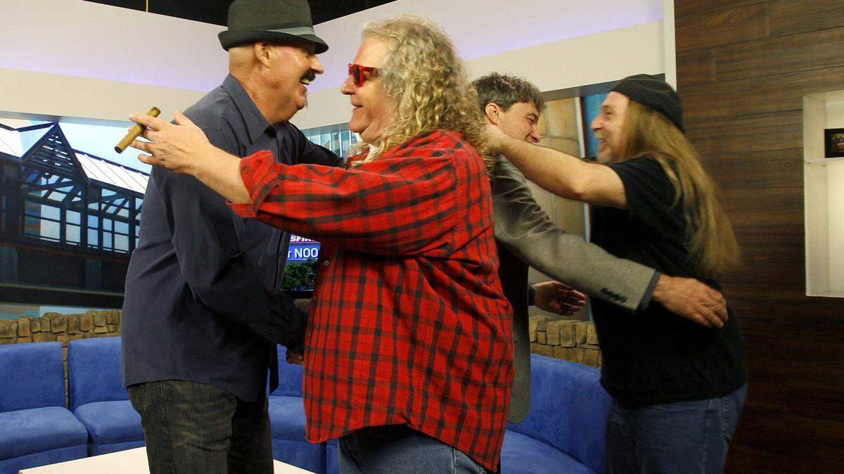 Exile's Marlon Hargis, left, greeted Richard Young of The Kentucky Headhunters and Exile's Steve Goetzman hugged Headhunters' Greg Martin at the Kentucky Music Hall of Fame and Museum announcement Tuesday at WKYT studios. Both groups are among the musicians to be inducted in 2013.      