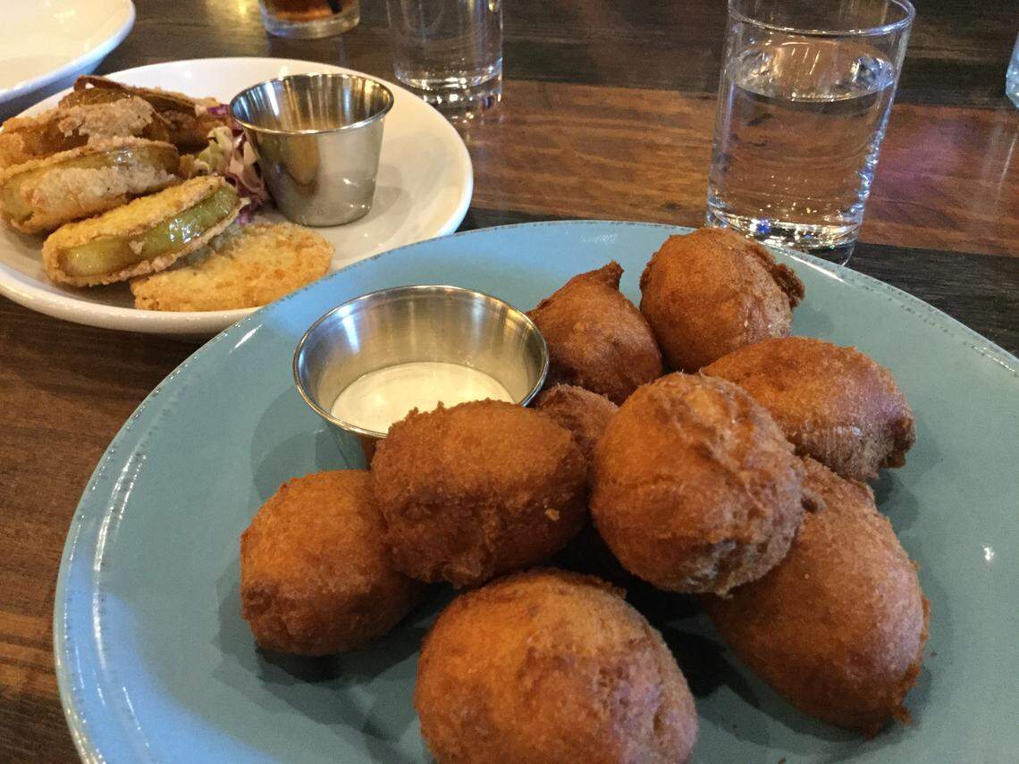 Appetizers on the menu at Nash’s Southern Table & Bar include hush puppies with garlic aioli and fried green tomatoes.