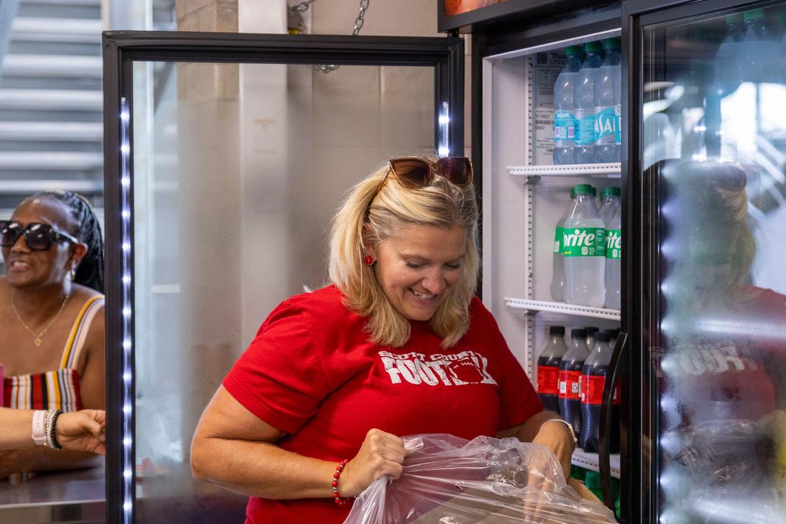 Scott County football booster president Brooke Miracle helps stock the new concession stand.