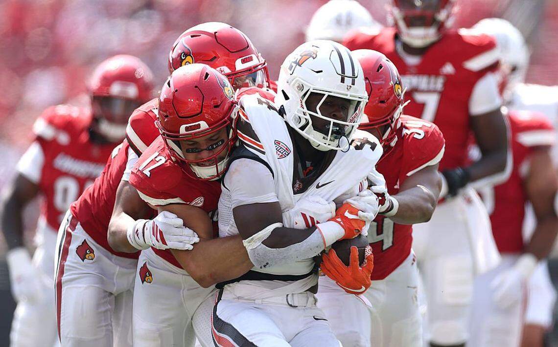 Louisville linebackers TJ Quinn (34) and Kalib Perry (12) combined to tackle Bowling Green’s Chris McMillian (4) during the Cardinals 40-17 win over the Falcons on Sept. 20.