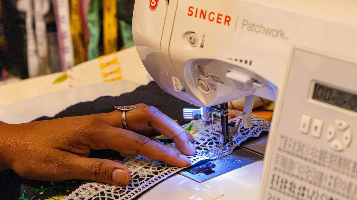 Local artist and activist fashion designer, Soreyda Benedit Begley, keeps the patterns and materials true to traditional garments, sewing the trim for an elaborate doll costume in her small home studio on Jan. 21, 2026, in Lexington, Ky.