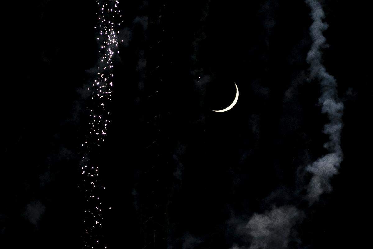 The moon is seen in between two firework trails during the city of Lexington’s Fourth of July fireworks display from the R.J. Corman Railyard in Lexington Ky., Thursday, July 4, 2019.