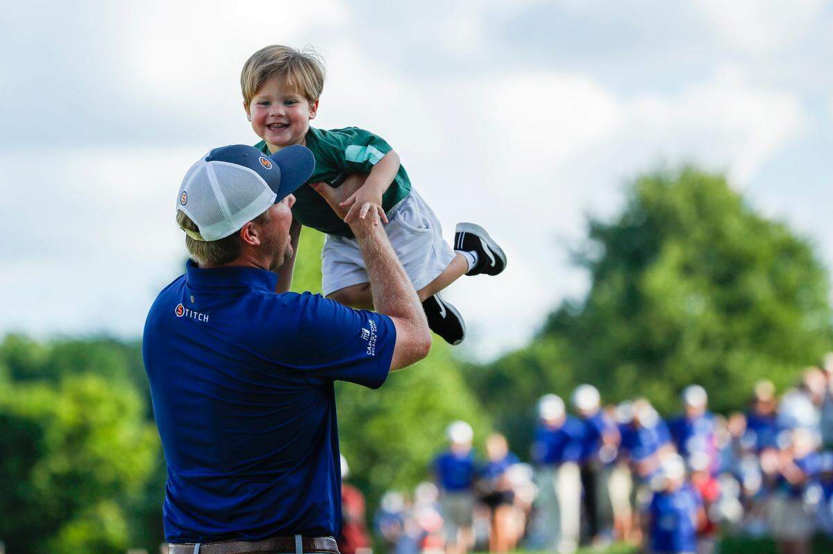 Trey Mullinax celebrates with his family after sinking a putt on the 18th hole to win the Barbasol Championship at Keene Trace Golf Club in Nicholasville on Sunday.