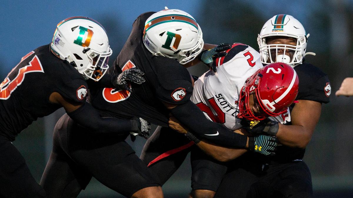 Three Frederick Douglass Broncos defenders combined to stop Scott County’s Montago Jones on Sept. 24. The teams meet again Friday night.