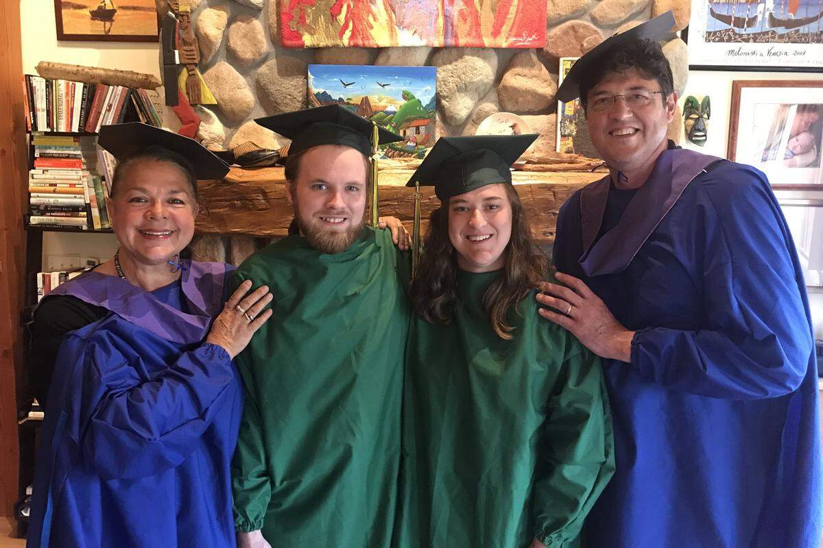 Former UK basketball player Chuck Verderber, right, and his wife, Lynda Ulrich, left, donned Kentucky blue surgical gowns during a homemade graduation ceremony for daughter Louisa and her boyfriend, Paul Barber, last weekend. The graduates wore the school colors of Clarkson University, which canceled its ceremony.