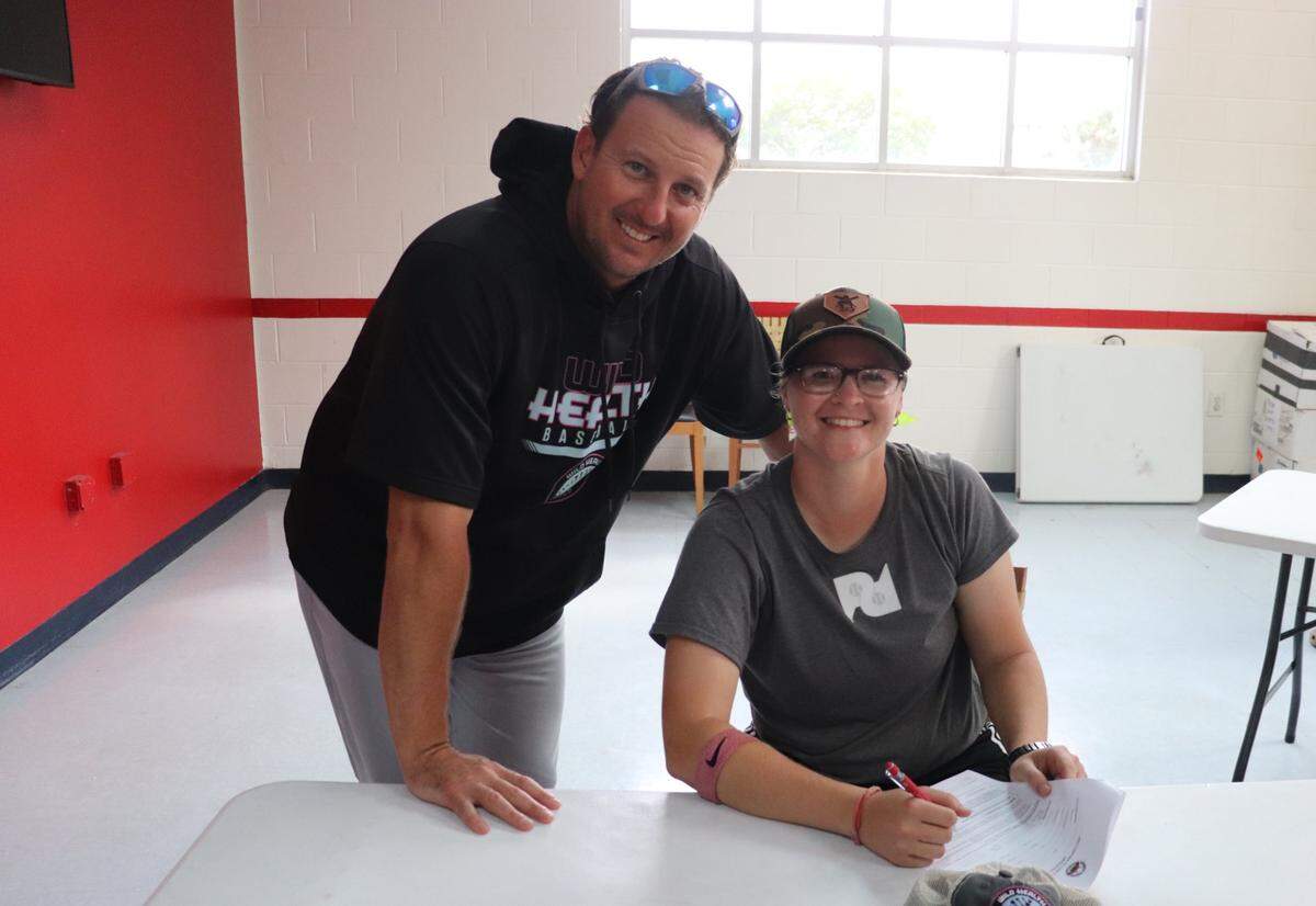 Kentucky Wild Health Genomes Manager Mark Minicozzi, left, and catcher Alexis “Scrappy” Hopkins sign a contract after Hopkins was picked by the Genomes during the Atlantic League’s annual player draft in Florida. According to the Genomes, Hopkins is believed to be the first female position player ever drafted by an American pro baseball team for an on-field role. Hopkins is expected to be the Genomes’ bullpen catcher.