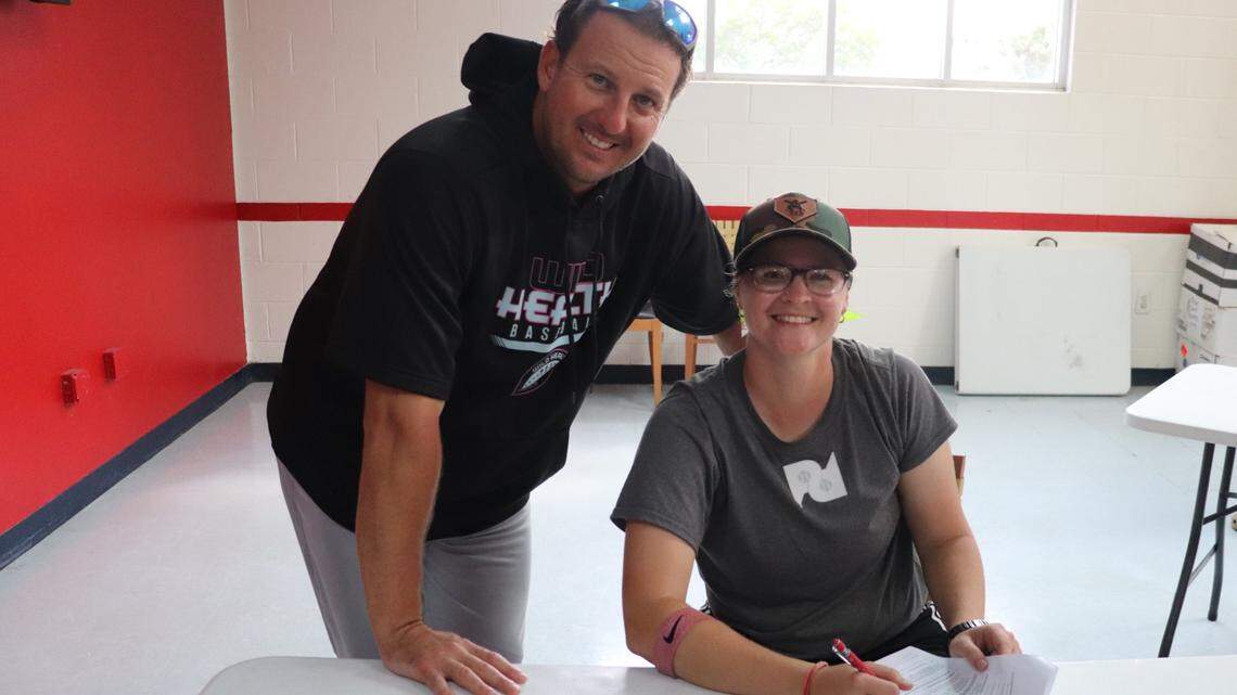 Kentucky Wild Health Genomes Manager Mark Minicozzi and catcher Alexis “Scrappy” Hopkins sign a contract after Hopkins was drafted by the Genomes during the Atlantic League’s annual player draft in Florida. According to the Genomes, Hopkins is believed to be the first female position player ever drafted by an American pro baseball team for an on-field role. Hopkins is expected to be the Genomes’ bullpen catcher.
